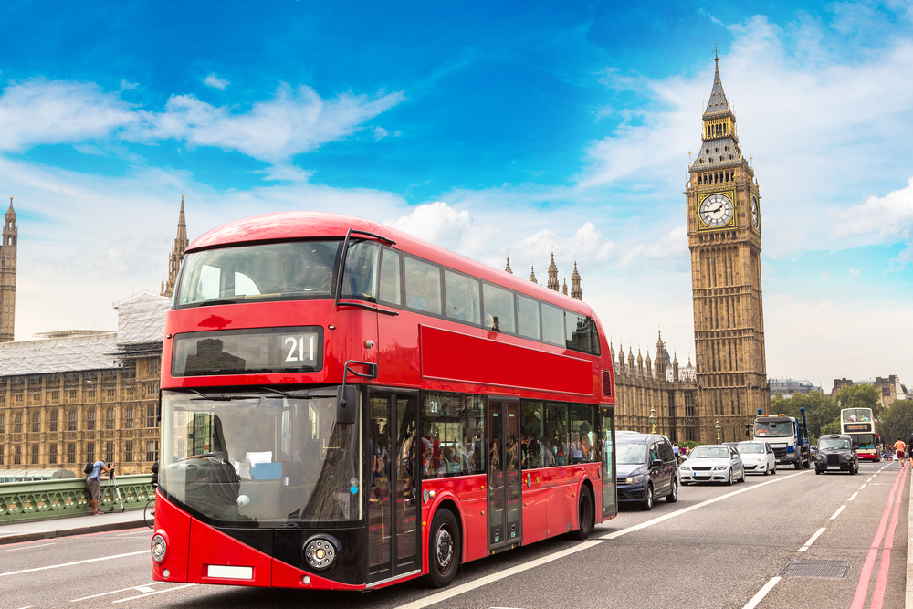 Double decker red bus travels through London with Big Ben in the background for a section showing how to book attractions on Expedia and Booking.com