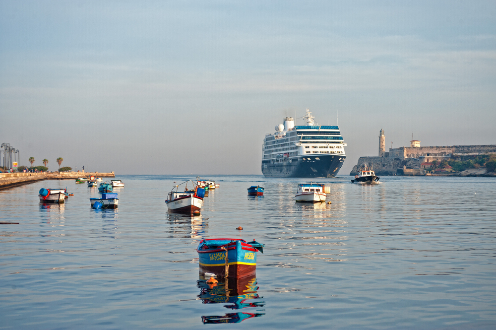Photo of an Azamara cruise ship docked in the bay at Havana with several other small boats, an image for a guide on Caribbean cruise cost.