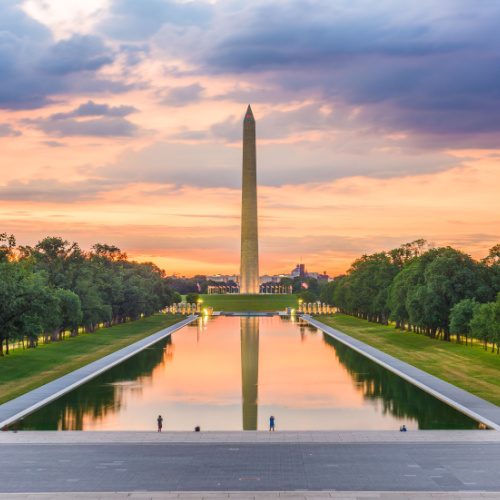 a vertical monument reflected on the reflection pool, during a sunset on one of the best time to visit Washington.