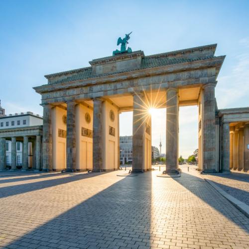 a huge structure that serves as a gate with a figure of a winged being on the top, can be seen during a sunset of the best time to visit Germany.