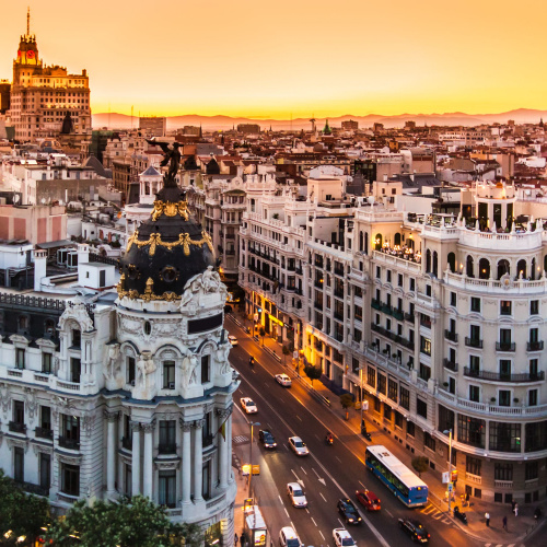 aerial view on an intersection in a city during a sunset of the best time to visit Spain, where the buildings are old and has sophisticated designs.
