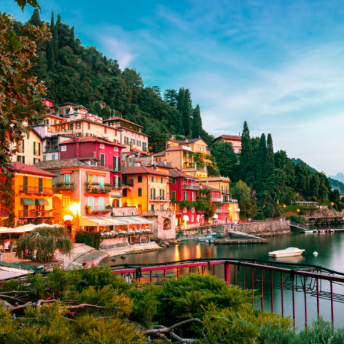 structures on the steep side of the lake, facing the calm water on a dusk of the best time to visit Italy.