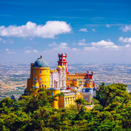a castle on top of a hill in a country, overlooking the vast town during the best time to visit Portugal.