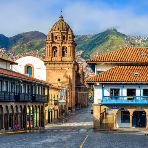 an old town in a country where an old church building can be seen along with other historical structures, during on of the best time to visit Peru.