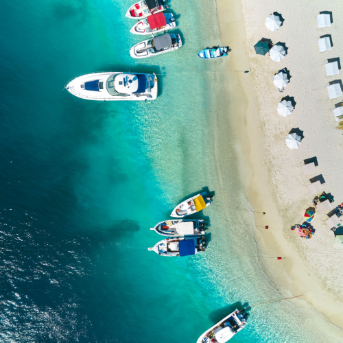 top view on a beach where the boats can be seen docked near the shore, and the water are emerald in color, photographed during one of the best time to visit Venezuela.