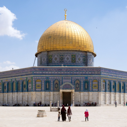 a symmetrical image of a large mosque with gold-colored roof during an afternoon on the best time to visit Palestine.