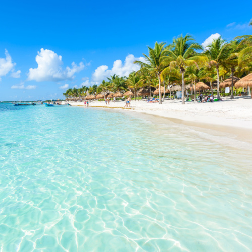 a hot afternoon on the best time to visit Riviera Maya in a white-sand beach with crystal clear waters.