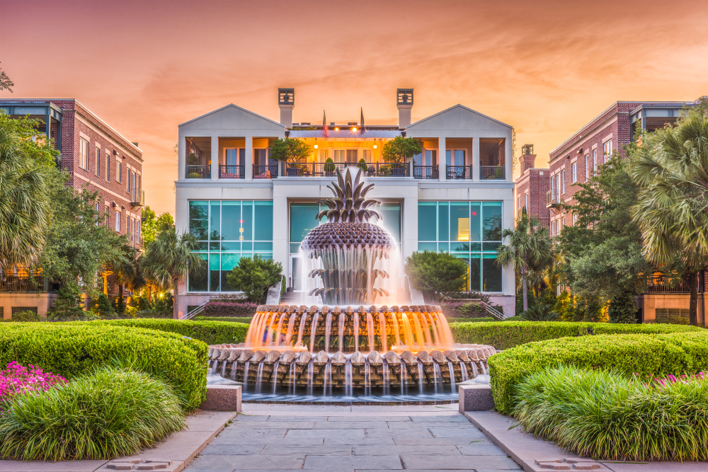 Photo of the waterfront area with the pineapple fountain pictured at dusk during the overall best time to visit Charleston, in the spring and fall