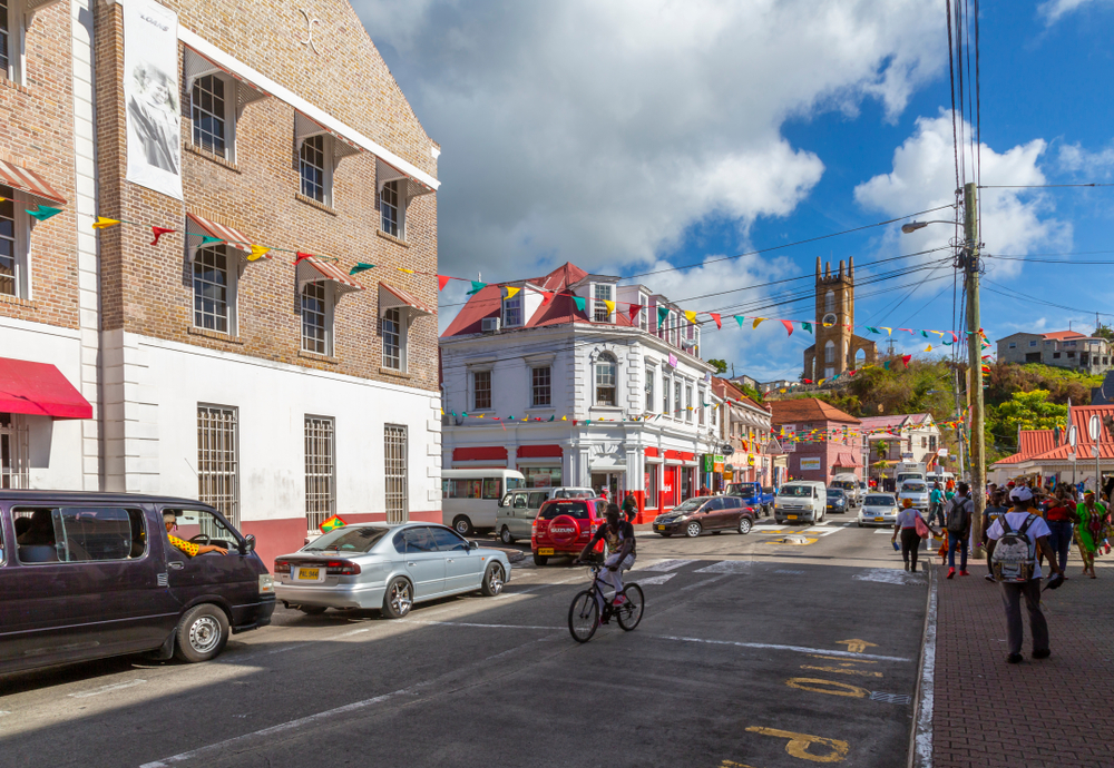 Pictured during the least busy time to visit Grenada, a photo of a semi-empty street in St. George's with colonial-style white and brown brick buildings