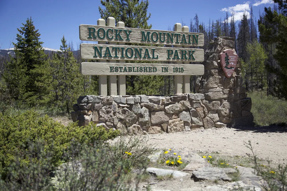 Rocky Mountain National Park entrance sign pictured sitting on rocks