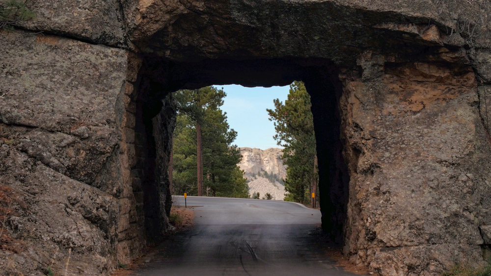 Unique square tunnel chiseled out of rock and offering a nice view of Mount Rushmore, seen during the fall, the cheapest time to visit