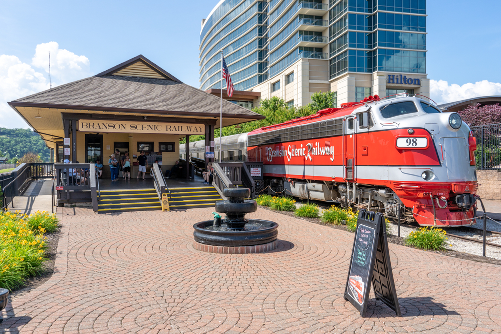 For a guide titled the best overall time to visit Branson Missouri, a photo of a red and silver train outside of the Branson Scenic Railway