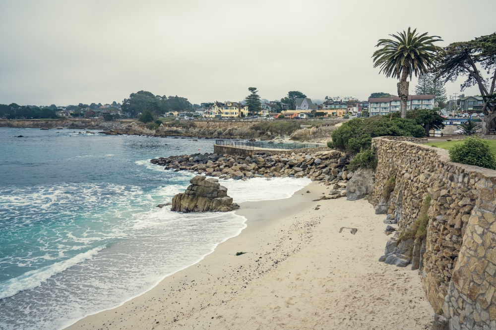Photo of a picturesque beach pictured with waves lapping the sand pictured for a guide to the best time to visit Monterey, CA