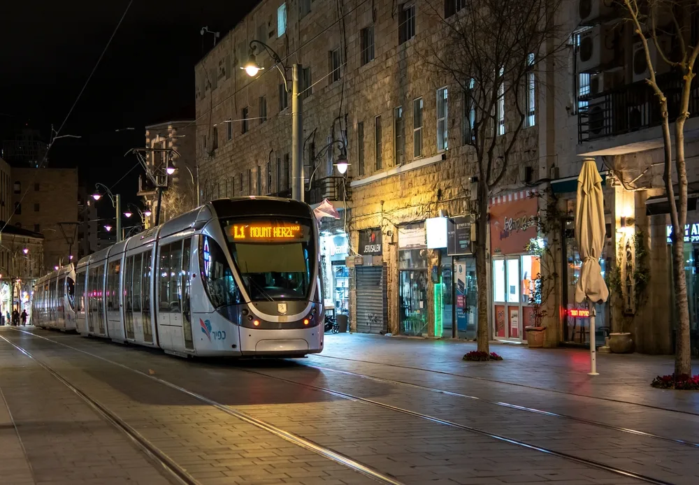 Photo of old town Jaffa pictured during the overall worst time to visit Israel with a tram making its way down the street at night