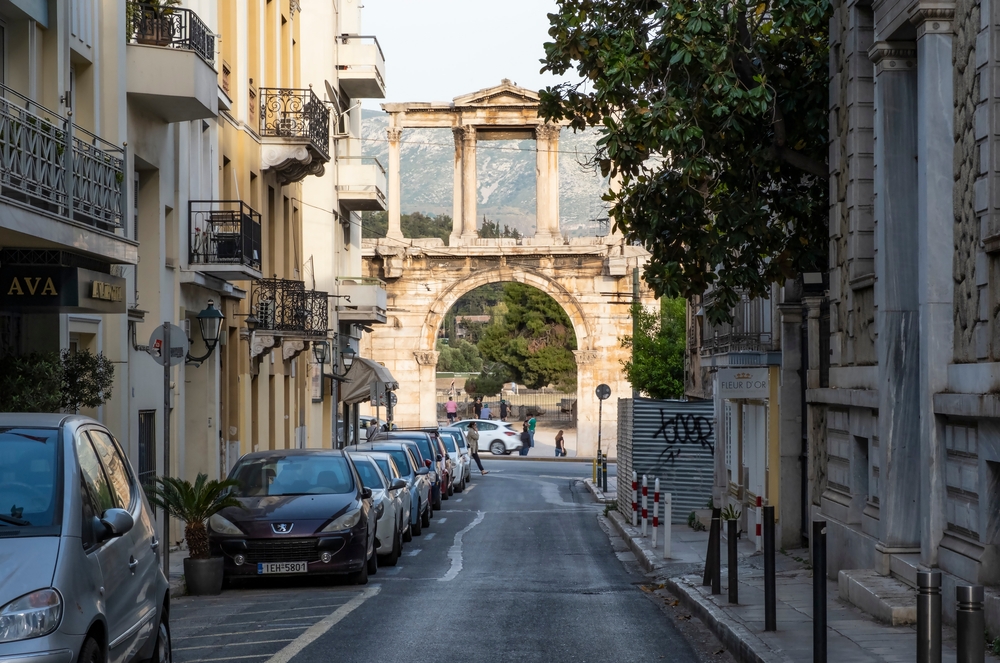 End of the street with the Arch of Hadrian in a historic old part of town pictured during the best time to visit Athens, the spring