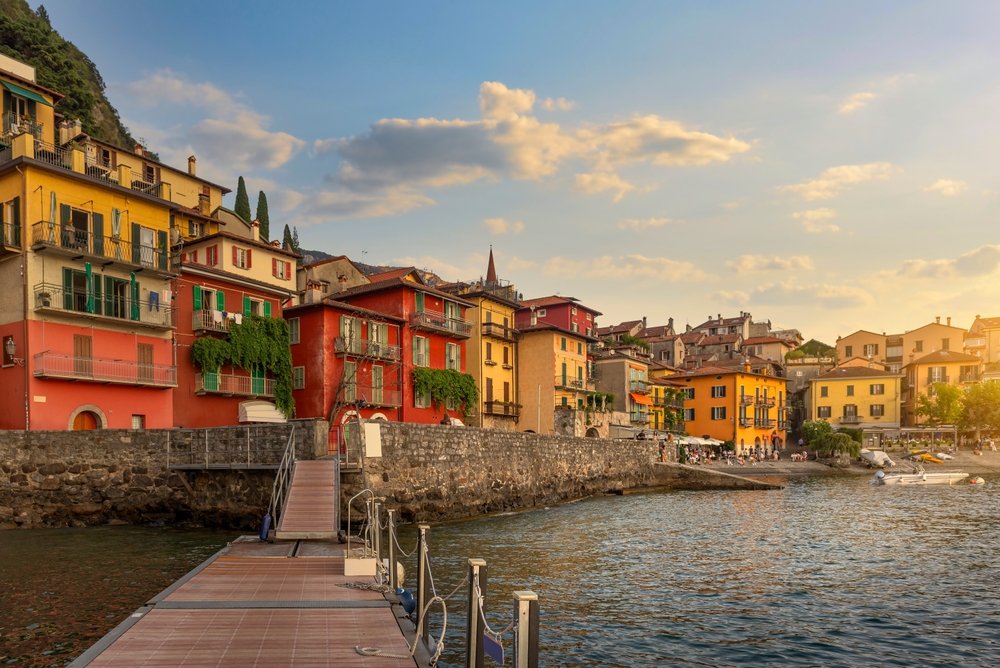 Sunset over Varenna's yellow and red buildings pictured in the spring, the overall best time to visit Lake Como