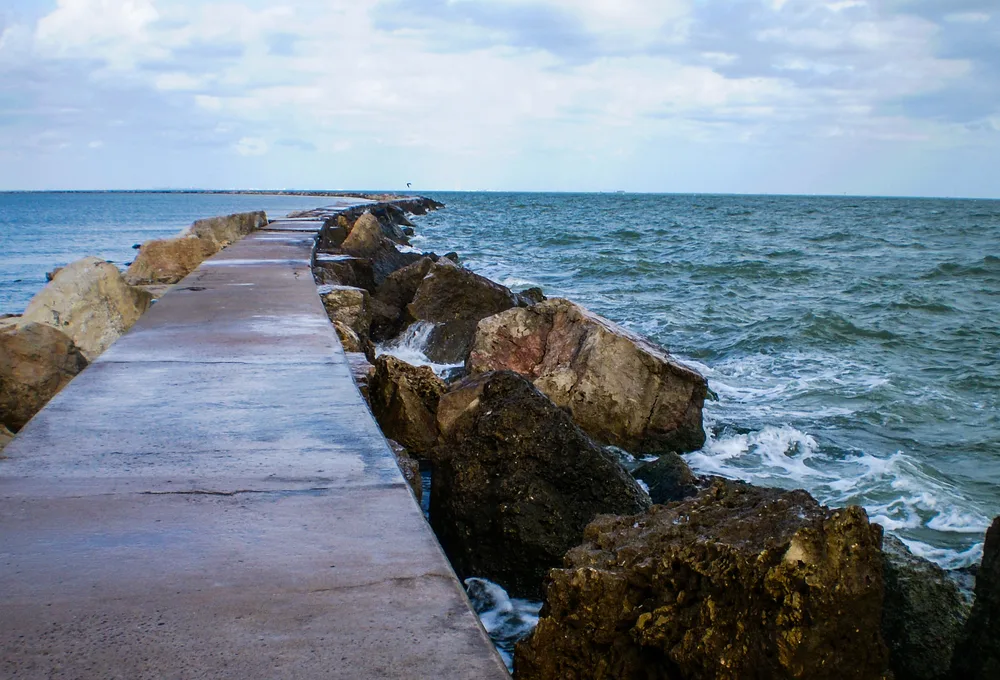 Walking path on a jetty pictured jutting into the ocean, as seen during the worth time to visit Corpus Christi