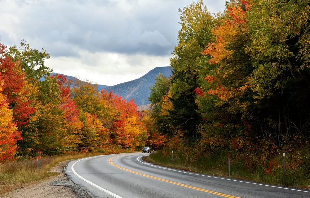 Extremely pretty winding Kancamagus Highway seen at White Mountain during the best time to visit New Hampshire, in Autumn