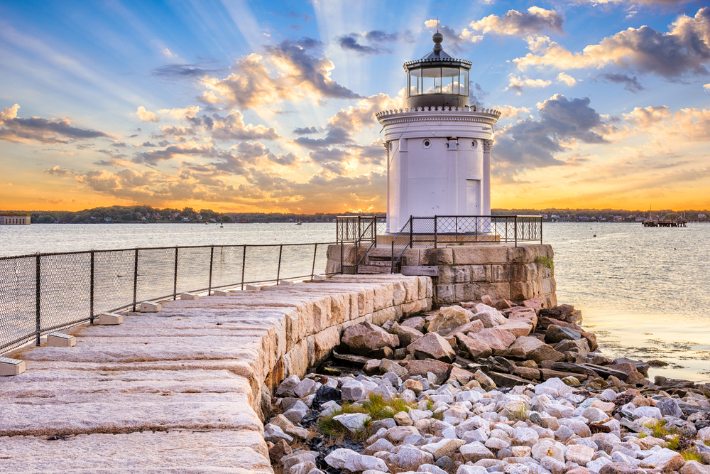 Neat view in the middle of summer, the overall best time to visit Portland, Maine, pictured with gorgeous rays of light streaking up high above the bay
