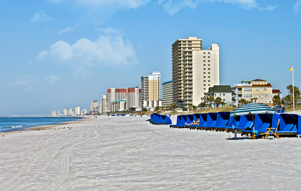Completely empty beach with blue loungers sitting on the beach pictured during a clear day during the least busy time to visit Panama City Beach