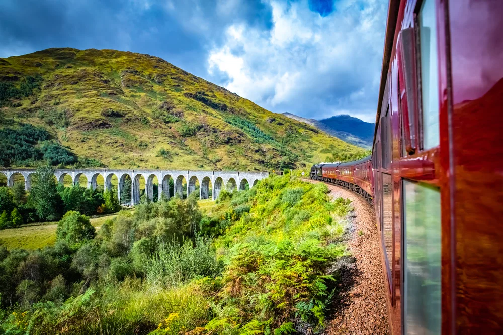 Red carriage of the Glennfinnan Railway in Scotland, pictured during the best time to visit the country