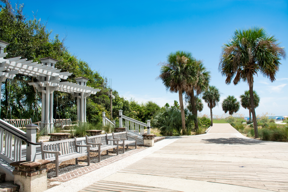 Boardwalk pictured during the least busy time to visit Hilton Head with a pergola and benches lining the trees