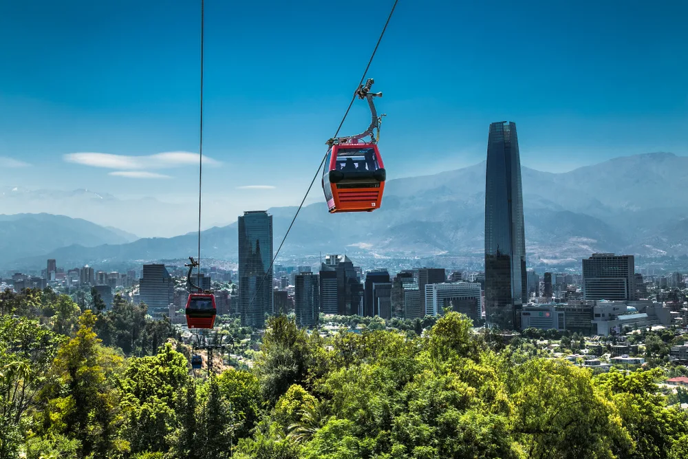 Red cable car making its way across the valley high above Santiago Chile during the city's best time to visit