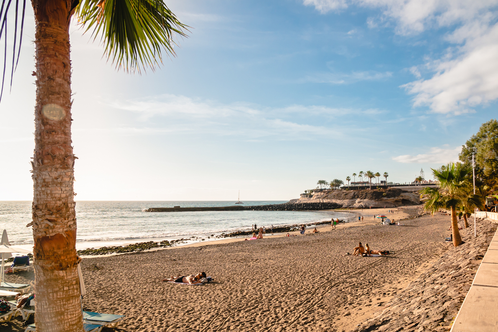 Empty day on the beach in Tenerife pictured with combed sand and gorgeous blue sky overhead