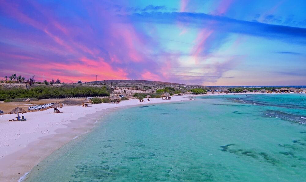 Gorgeous pink sunset over Baby Beach on Aruba during the overall best time to visit the Caribbean