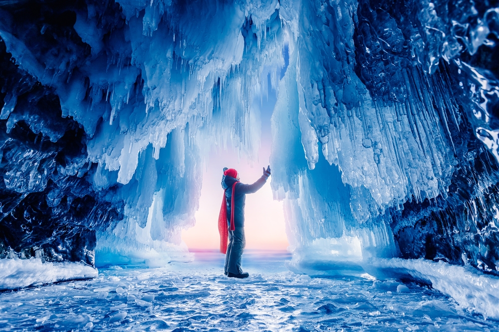 Man in an ice cave being awed with the gorgeous scenery in Baikal