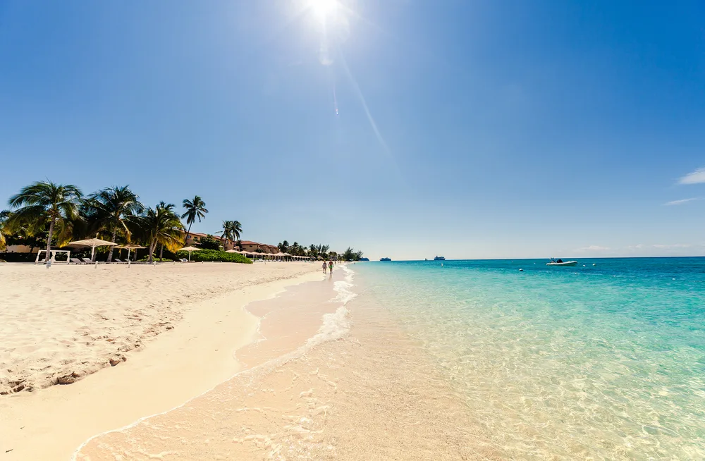 Photo of Seven Mile Beach pictured during the overall best time to visit the Cayman Islands with blue sky overhead and a white sand beach next to the teal water