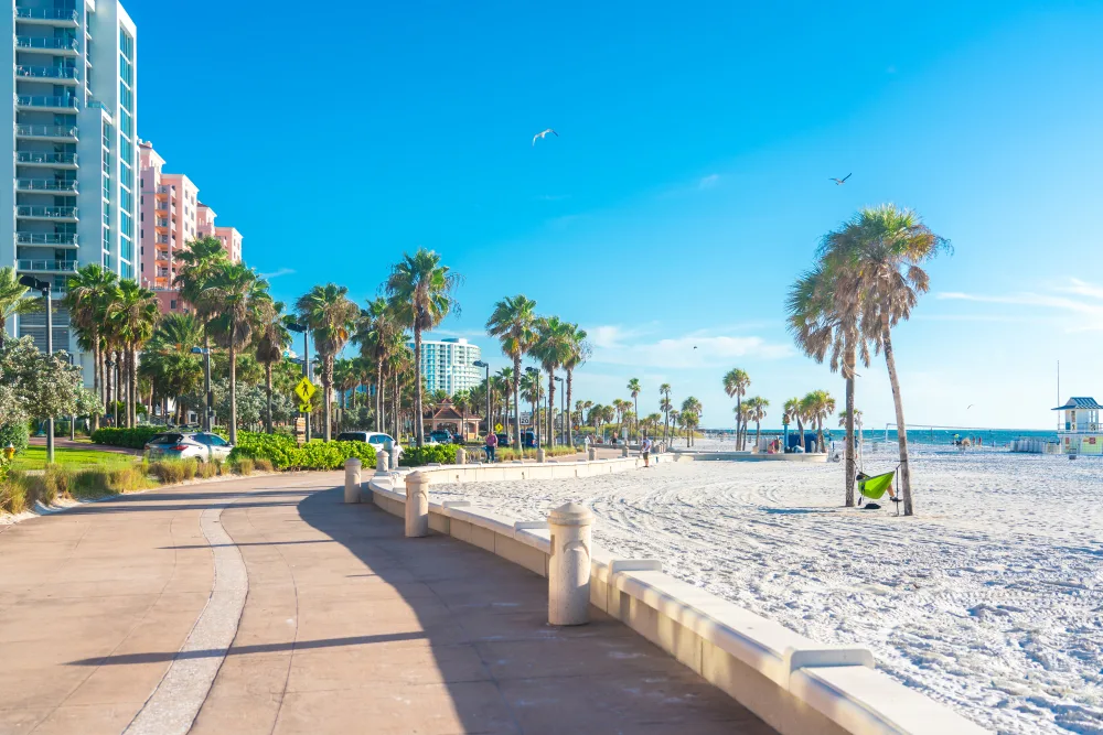 Photo of Clearwater Florida pictured during the overall best time to visit with the walkway next to a white sand beach under blue sky