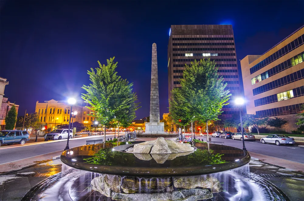 Photo of a serene night scene pictured during the least busy time to visit Asheville with a calm purple night sky pictured above the downtown skyline