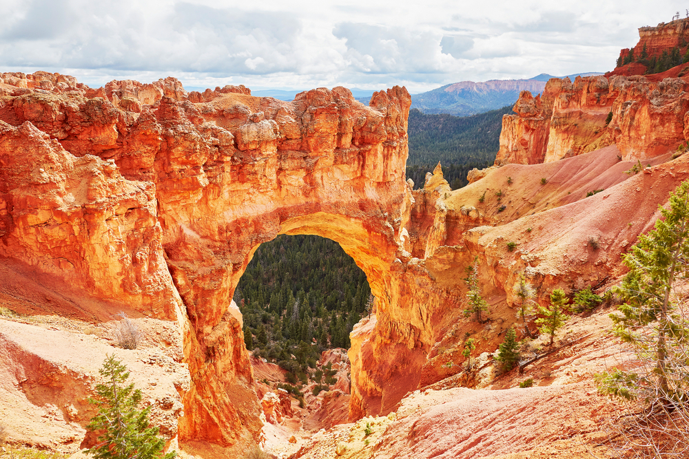 Natural bridge rock formation in Bryce Canyon pictured during the best time to visit with rocks spanning the valley below