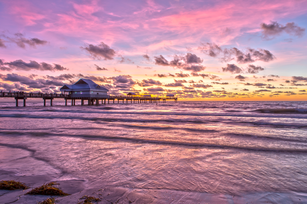 Orange and pink sky over the water during the best time to visit Clearwater, Florida