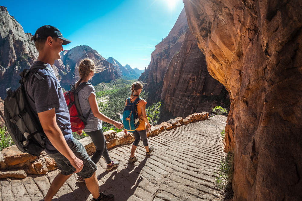 People walking down a grated walkway wearing backpacks during the overall best time to visit Zion National Park