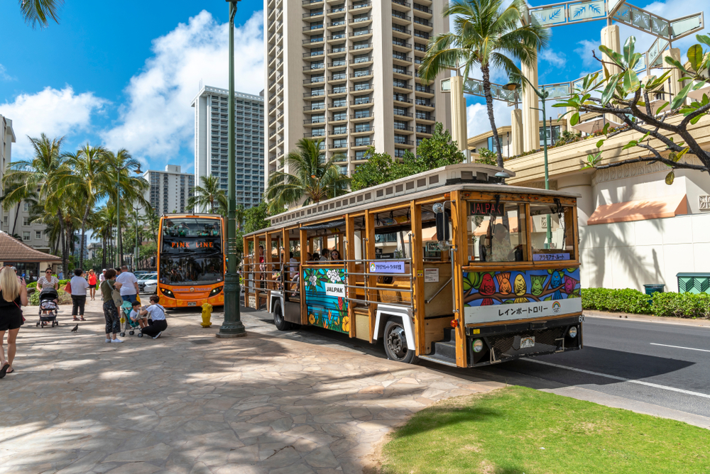 Photo of a bus between buildings in Honolulu during the spring, one of the least busy times to visit Oahu