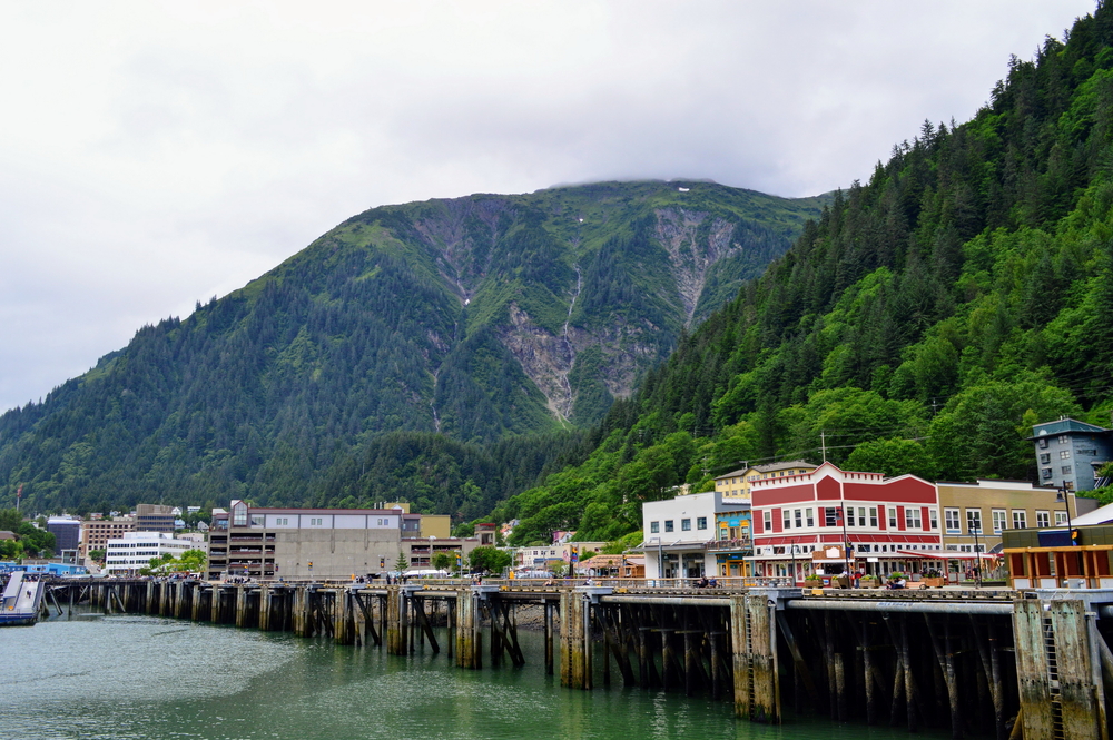 Scenic view of a cruise port in Juneau, Alaska, seen during one of the best times to visit, the spring or summer, with a few clouds low over the hills