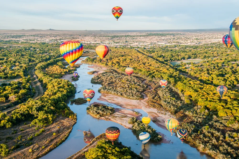 Balloons over the Rio Grande river in New Mexico during the overall best time to visit New Mexico