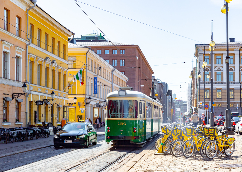 Photo of a green trolley making its way down the tracks in Helsinki during June, one of the overall best times to visit Finland