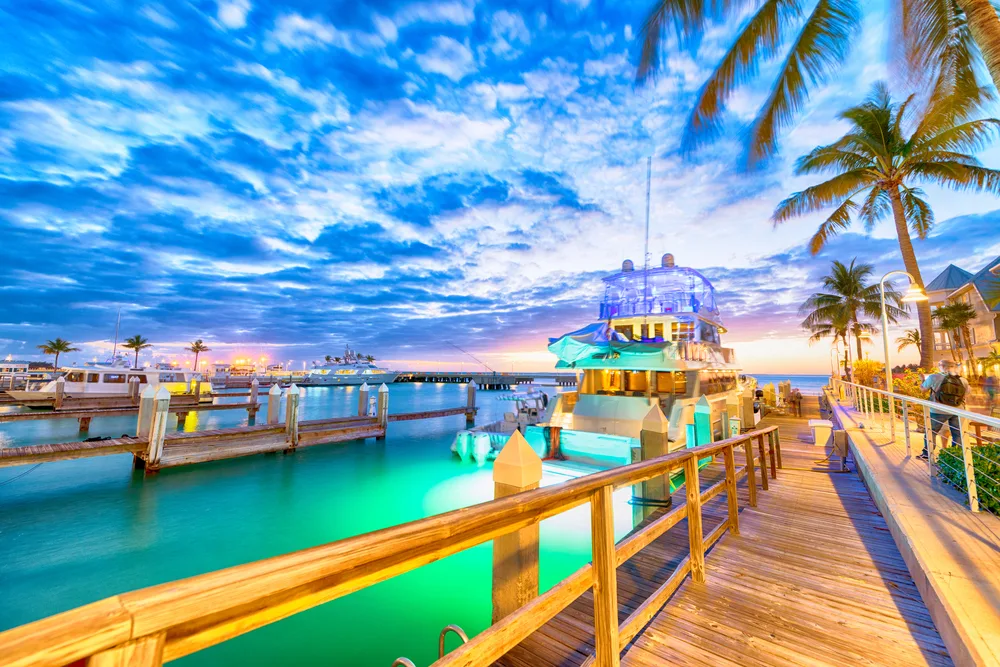 Neat view of the colorful teal water with lights on it in Key West pictured during dusk during the best time to visit