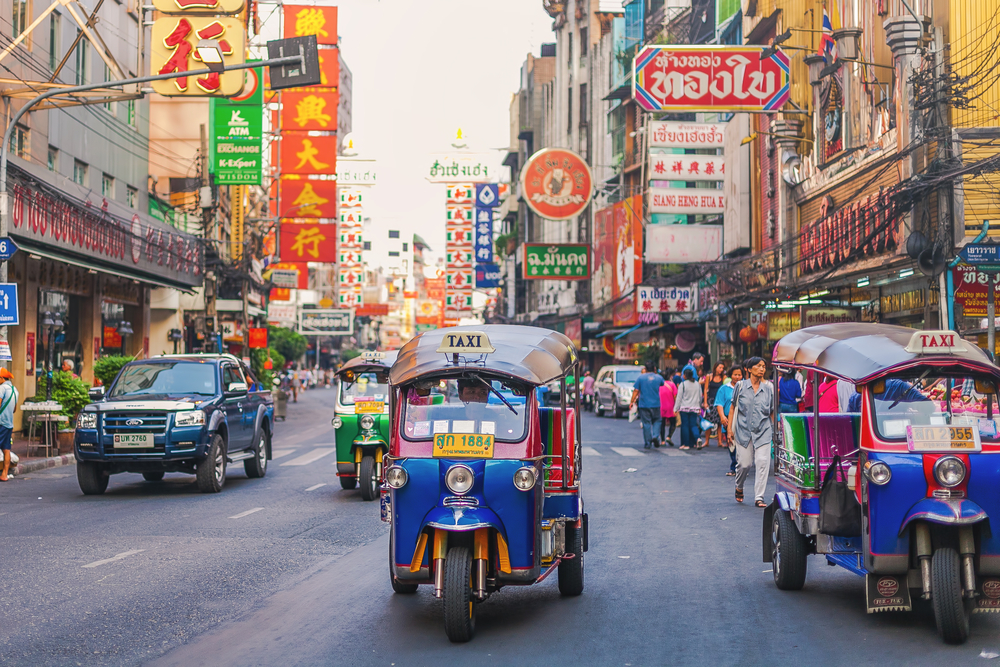 Photo of people riding Tuktuks in the Chinatown area of Bangkok during the fall, one of the least busy times to visit Thailand