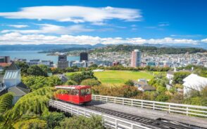 View of the capital city of Wellington and its famous red cable car moving through the countryside outside the city for a guide showing the best time to visit New Zealand