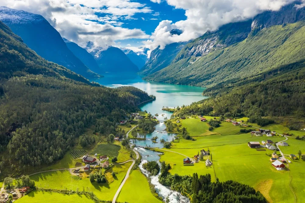 Lovatnet Lake in Lodal Valley seen aerially on a clear summer day with lush green mountains and the fjord during the best time to visit Norway