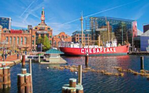 Gorgeous view of the USS Chesapeake with a full view of the downtown and its historic buildings, as seen during the best time to visit Baltimore