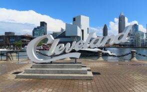 Photo of a Cleveland sign and the downtown skyline in the background pictured during the overall best time to visit Cleveland Ohio