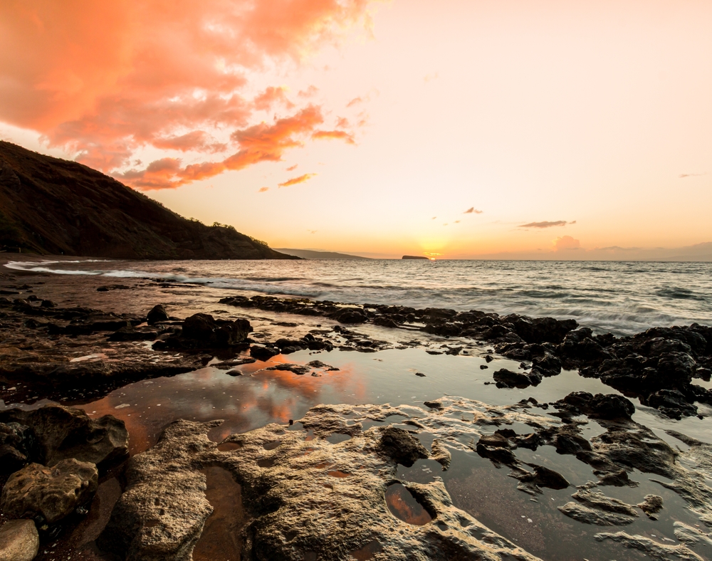 Sunset on the exposed lava formations of Oneuli black sand beach on Maui
